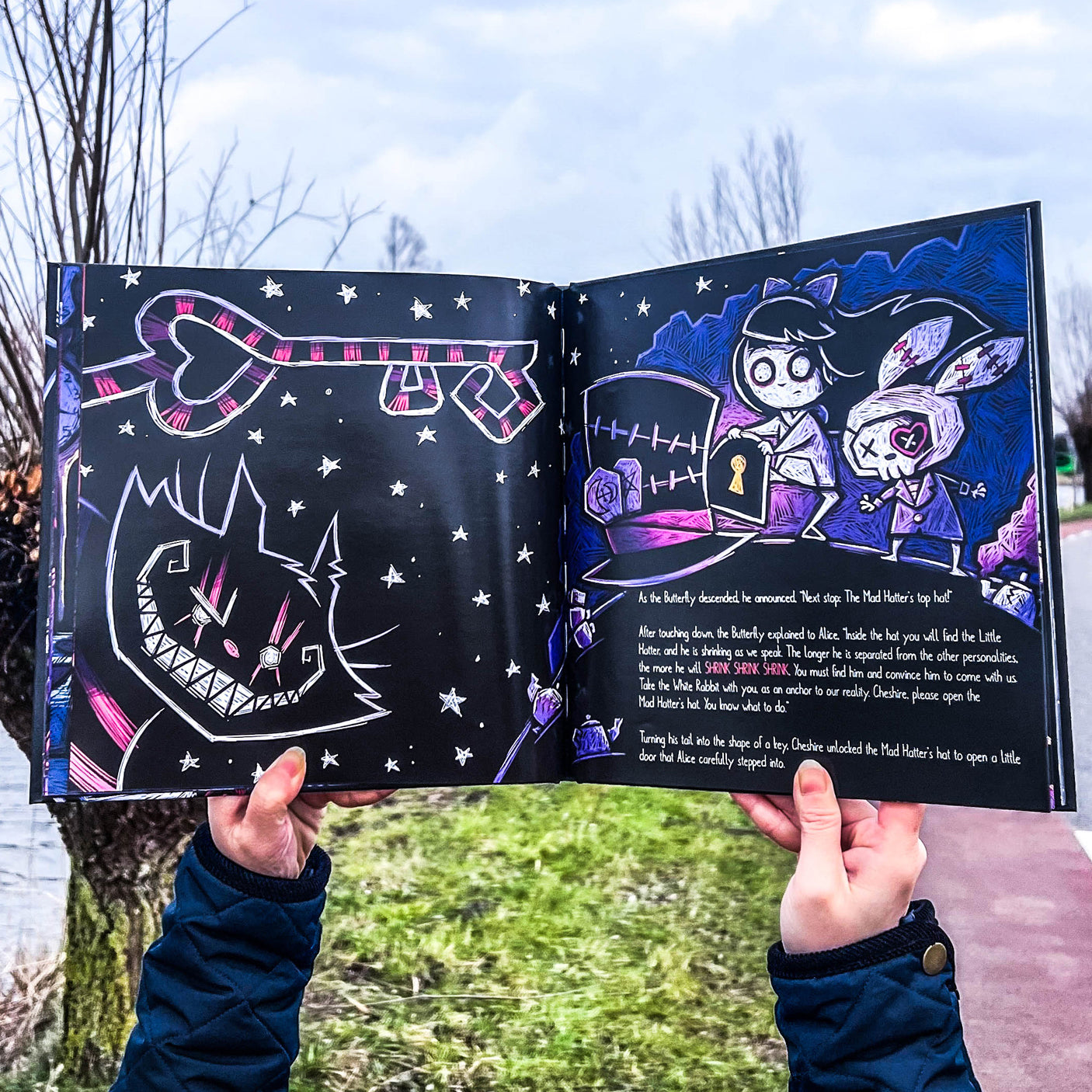Open gothic storybook showing horror-inspired Wonderland artwork and text